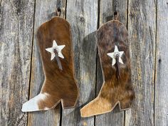 two brown and white cowhide boots with stars on them sitting on wooden planks