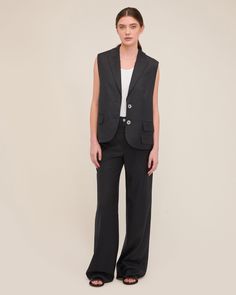 The Olivia is a modern take on the classic blazer vest. With its relaxed fit, dropped armhole and luxurious wool, this light suit vest lends itself to many styling choices. Layer over your favorite tank or button-up shirt or dare to wear her alone as a statement piece. For a polished yet edgy pairing, wear the Olivia with the Obie Asymmetrical Double Waist Trouser. Relaxed fit Notch collar with traditional blazer details Single breasted, button closure Sleeveless Dropped armholes Light shoulder Classic Sleeveless Office Blazer, Notch Lapel Vest With Pockets For Business Casual, Notch Lapel Business Casual Vest With Pockets, Business Casual Notch Lapel Vest With Pockets, Tailored Blazer With Vest For Office, Sleeveless Single Breasted Blazer For Business, Sleeveless Single-breasted Business Blazer, Tailored Sleeveless Blazer With Pockets, Sleeveless Tailored Blazer With Pockets