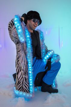 a man dressed in blue and black poses for the camera with his fur coat on