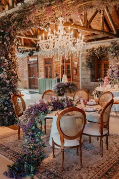 the dining room is decorated with flowers and chandelier hanging from the ceiling, along with wicker chairs