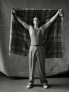 a man standing in front of a plaid blanket