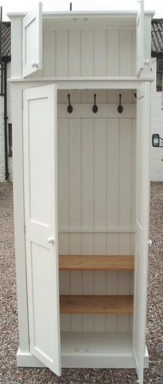 an open white cabinet with wooden shelves and hooks