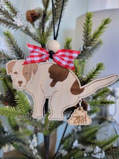 a wooden ornament with a dog on it's back hanging from a christmas tree