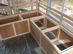 the inside of a wooden bench with windows on it's sides and wood framing