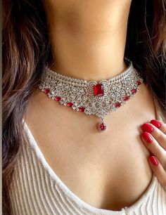 Gorgeous fine quality lab diamonds studded in white gold rhodium plating with  Red stones and high quality zirconia. This beautiful choker  set can be paired well with any outfit, be it ethnic or indo-western. What's more, it shines and blings in the right light! For any queries, please feel free to contact us. Happy shopping!  Comes with matching earrings. AAA quality cubic zirconia used. Highest quality and craftsmanship Item includes: Necklace, Earrings and Maangtika Necklace length 14 inches Silver Diamond Necklace With Stone Work, Dazzling Silver Kundan Necklace With American Diamond, Festive Silver Diamond Necklace, Festive Silver American Diamond Necklace, Diamond Jewelry Sets With Stone Work, Silver Diamond Necklace With Stone Work For Wedding, Silver Kundan Necklace With Hand-set Cubic Zirconia, Silver Kundan Necklace With Hand Set Cubic Zirconia, White Gold Diamond Choker For Wedding