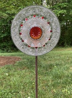 a glass plate on top of a metal pole in the middle of a grass field