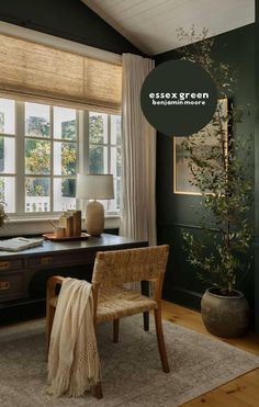 a desk with a chair, lamp and potted plant in front of the window