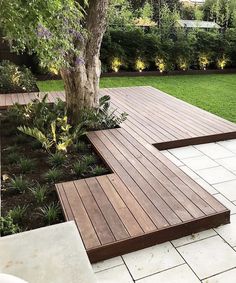 a wooden bench sitting next to a tree on top of a white tile flooring