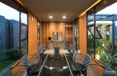 a dining room with glass walls and wooden flooring