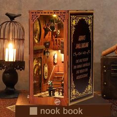 an open book with some items inside of it on a table next to a lamp