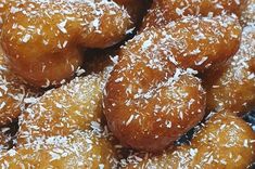 a pile of doughnuts covered in sugar and sprinkled with sesame seeds