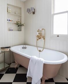 a bathroom with a claw foot bathtub and black and white checkered flooring