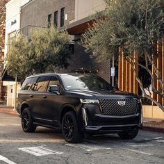 a black suv parked in front of a building