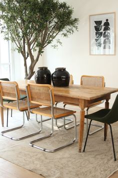 a dining room table with chairs and vases on it