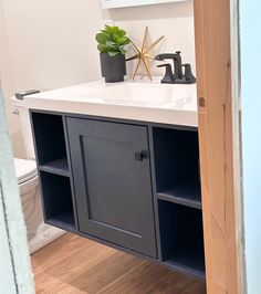 a bathroom with a sink, toilet and wooden cabinet in it's center area