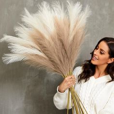 a woman is holding some dry grass in her hands