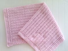 two pink crocheted blankets sitting on top of each other