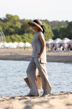 "Minimalist White Linen Sleeveless Blouse The front and back are asymmetrical The model is made of 100% linen Match with: https://www.etsy.com/uk/listing/1485598564/white-linen-pants-linen-wrap-pants-wide The white linen fabric is not optical white White linen fabrics are always transparent HEIGHT OF MODEL: 168 cm. / 5′ 6″  Size S We accept Returns and Exchange All garments are handmade. Please provide your PHONE NUMBER for delivery   EXPRESS delivery for ALL ORDERS   Accessories are not for sale. If you have different measurements please inform us. SIZE CHART (measurements of the body NOT of the garment ) XS Bust 82 - 84 cm | 32.28 - 33.07\" Waist 63 - 67 cm | 24.80 - 26.38\" Hips 86 - 90 cm | 33.86 - 35.43\" Inseam 74 cm | 29.13\" Inseam Long 84 cm | 33.07\" S Bust 86 - 90 cm | 33.86 - 3 Sleeveless Linen Tank Top For Beach, Versatile Beach Tank Top, Beach Sleeveless Linen Tank Top, White Linen Fabric, Blouse Summer, Pants Linen, Wrap Pants, Linen Fabrics, White Linen Pants