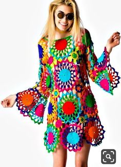 a woman in a colorful crochet dress with sunglasses on her head and arms outstretched