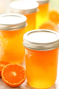 several jars filled with orange juice on top of a table