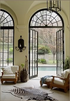 a living room filled with furniture and large windows