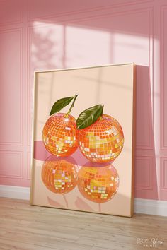 two oranges with green leaves on them in front of a pink wall and floor