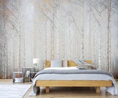 a bed sitting in front of a wall with trees on it