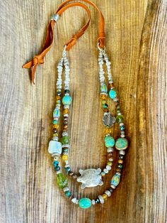 This colorful, double strand, Sundance style beaded necklace is a blend of my favorite colors, blues, yellow, rustic brown and Peridot green. I used tiny freshwater seed Pearls to start it off. Then blended faceted turquoise rounds, Blue and Yellow Chevron beads, a white freshwater Coin Pearl, 4 stunning Kingman Turquoise nuggets, Three natural Peridot nuggets and a ton of Hilltribe Silver! A Hilltribe Silver Turtle is the focal on the first strand. This hangs from Carmel colored very soft , but Adjustable Double Strand Bohemian Turquoise Necklace, Bohemian Multi-strand Adjustable Turquoise Necklace, Adjustable Multi-strand Bohemian Turquoise Necklace, Adjustable Bohemian Multi-strand Turquoise Necklace, Green Double Strand Bohemian Turquoise Necklace, Green Turquoise Double Strand Bohemian Necklace, Green Bohemian Double Strand Turquoise Necklace, Turquoise Double Strand Bohemian Jewelry, Unique Turquoise Double Strand Beaded Necklaces