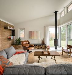 a living room filled with furniture and a fire place in front of a window covered wall