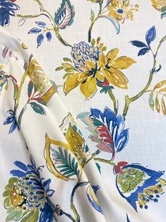 an image of a floral print on white fabric with blue, yellow and green flowers