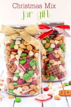 two jars filled with christmas mix sitting on top of a table