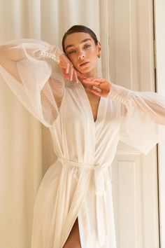 a woman in a white robe posing for the camera