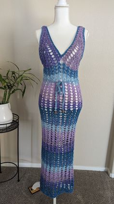 The "Ocean Twilight Dress" is a stunning handmade crochet piece that features a delicate mesh pattern, perfect for beachwear or summer outings. Its variegated hues transition smoothly from deep purples to serene blues, creating a captivating ombré effect reminiscent of a twilight sky over the ocean. The dress boasts a flattering V-neckline and adjustable tie at the waist, accentuating the figure while maintaining an airy, bohemian charm. This versatile and elegant dress is a unique blend of artistry and comfort, ideal for those seeking a stylish yet relaxed look. CUSTOM MADE ORDER: Choose the color, size, and material for a unique product. Experience the perfect combination of style and functionality with custom options tailored to your liking. Multicolor Beachy Crochet Dress For The Beach, Multicolor Crochet Beach Dress For Beach Party, Multicolor Crochet Beach Party Dress, Bohemian Sleeveless Beach Dress With Crochet Lace, Bohemian Sleeveless Crochet Lace Beach Dress, Multicolor Beachy Crochet Dress For Beach Season, Beachy Crochet Dress With Open Knit For The Beach, Bohemian Crochet Lace Dress For Beach Party, Bohemian Multicolor Crochet Dress For Beach