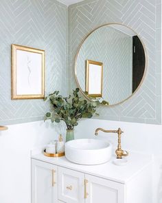 a bathroom with a sink, mirror and gold faucet on the counter top