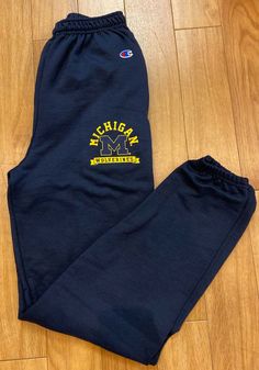 Champion Michigan Wolverines Mens Navy Blue Logo Sweatpants - 14751756 Navy Athleisure Bottoms For Sports Events, Casual Pants For Sports Season Events, Blue Team Spirit Sports Bottoms, Cotton Sports Bottoms With Team Spirit Style, Blue Joggers With Ribbed Cuffs For Sports, Sporty Navy Bottoms For Leisure, Cotton Bottoms For Sports Season Events, Cotton Bottoms For Sports Events, Blue Sweatpants With Ribbed Cuffs For Sports