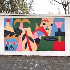 a large painting on the side of a building with trees in the backgroud