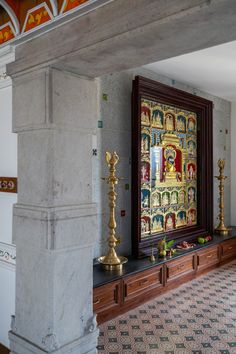 an ornately decorated room with gold candles and paintings on the wall, in front of a doorway