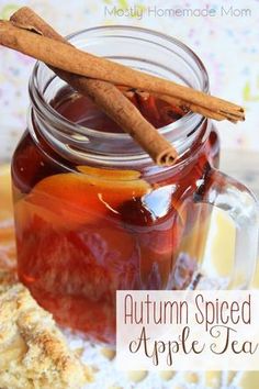 an apple cider in a jar with cinnamon stick sticking out of it and the words, autumn spiced apple tea