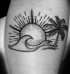 a black and white photo of a sun, palm tree and wave tattoo on the leg