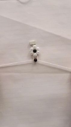 two pieces of clothing hanging on a white hanger with black and white pins attached to it