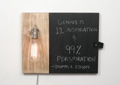 a light bulb mounted to a wall with a sign on it that says genius is 1 / 4 inspiration