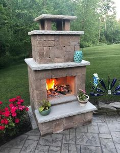 an outdoor fireplace in the middle of a yard