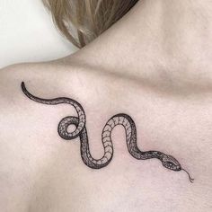 a woman with a tattoo on her chest has a snake in the shape of a heart