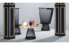 three black and gold chairs sitting next to each other on top of a white table