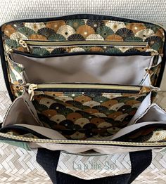 the inside of a handbag with an open zippered compartment and two compartments on each side