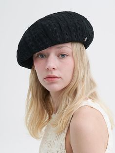 a woman with blonde hair wearing a black hat