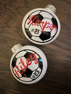 two soccer ball ornaments with the word happy on them