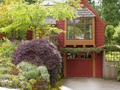 a red house surrounded by greenery and trees