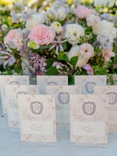 wedding stationery cards with monogrammed initials and floral bouquets in the background