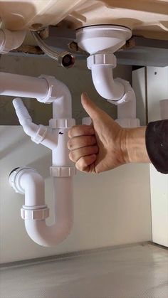 a man is giving the thumbs up to some pipes